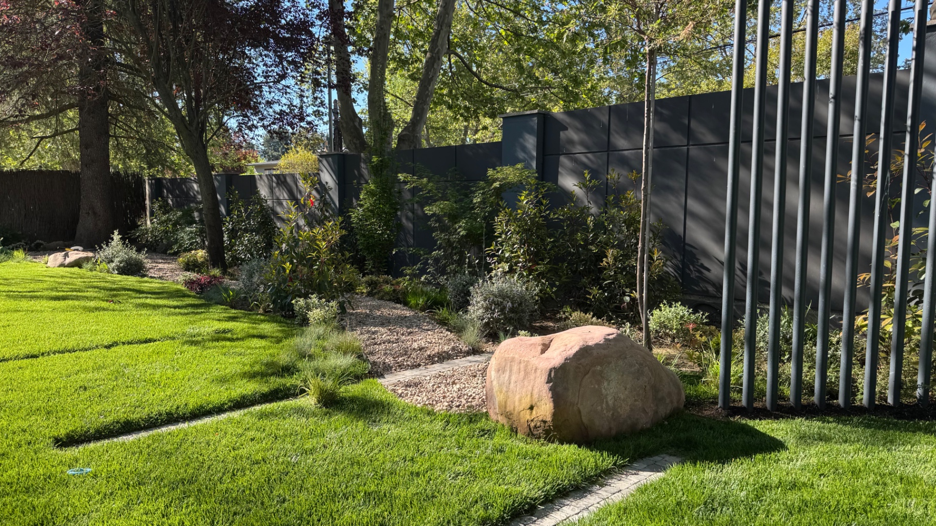 Estructura de pérgola integrada con vegetación y piedra